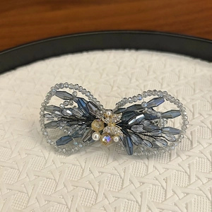 Vue macro d'une pince à cheveux en cristal avec perles bleues et détails raffinés