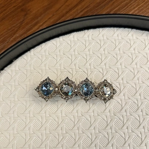 Detailed macro view of vintage barrette with deep blue gemstones and antique silver base