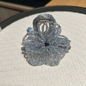 Vue macro de la pince à cheveux artisanale rose en perles bleues avec nœud en ruban