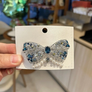 Vue détaillée de la barrette luxueuse en cristal avec gemmes bleues et pompons perles