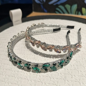 Dettaglio di strass marquise smeraldo e rosa su cerchietti in metallo argento
