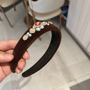 Close-up of velvet headband with rubies champagne rhinestones and white pearls