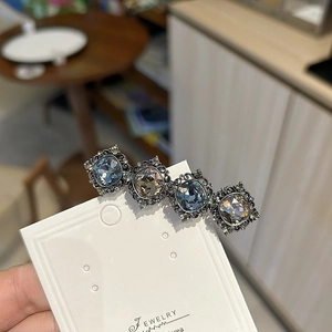 Detail of vintage square gem hair clip with blue and amber stones on filigree metal base