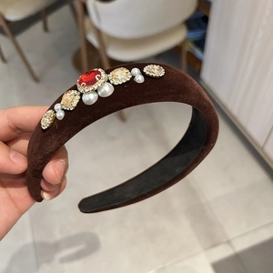 Detail of vintage black velvet headband with red crystals and pearls on top