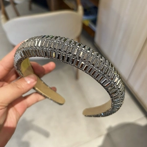 Détail du serre-tête rembourré tenu à la main orné de strass argentés de luxe étincelants
