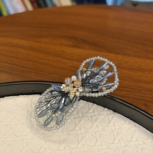 Détail de la pince à cheveux nœud en cristal tissé main avec papillon doré et perles