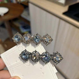 Detail view of vintage hair clips with blue and champagne crystals in antique metal frames