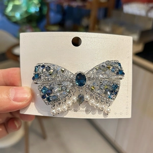 Barrette nœud de luxe en cristal avec perles bleues sur carte de présentation