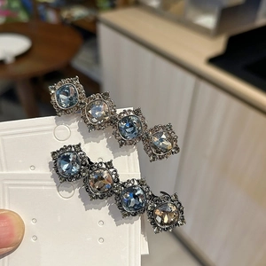 Close-up of vintage hair clips with square crystals in blue and champagne on a display card