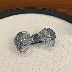 Gros plan sur une barrette nœud en cristal élégante avec des strass bleus et clairs