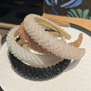 Détail de serre-têtes rembourrés avec cristaux étincelants en blanc, or et noir