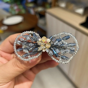 Détail de la pince à cheveux papillon en perles de cristal bleu et métal doré