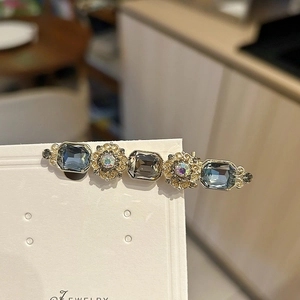 Vintage gold hair clip featuring emerald-cut grey-blue stones and floral metalwork