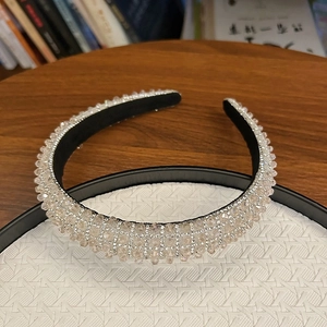 Luxurious pink crystal padded headband with sparkling silver mesh on woven display tray
