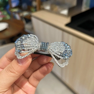 Vue détaillée de la barrette nœud en cristal bleu clair avec des strass étincelants