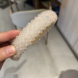 Détail d'un serre-tête en cristal avec perles dégradées rose et blanc en motif de vague V