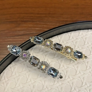 Detailed close-up of luxury vintage hair clips with blue crystals and gold-silver finish