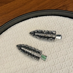 Close-up of crystal beaded hair clips with sparkling rhinestones and green gemstone