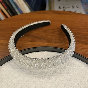 Detailed view of the dense crystal beaded headband with a black inner fabric lining