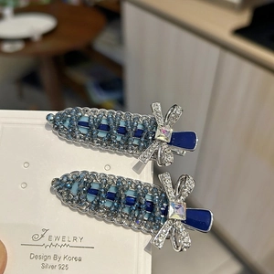 Close-up of blue crystal beaded hair clips with silver bow and square gemstone detail