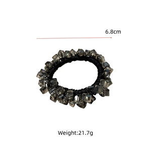 Close-up of black elastic hair tie with 6.8cm diameter smoked grey square faceted crystal beads