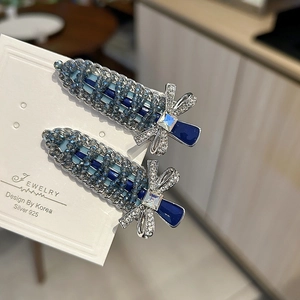 Detail of beaded sword hair clips with blue crystals and zircon butterfly bows