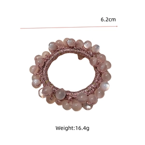 Detail view of pink beaded hair tie with 6.2cm diameter and 16.4g weight on white background
