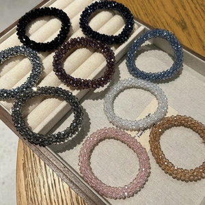 Close-up of faceted crystal bead hair ties in multiple colors displayed in a jewelry box