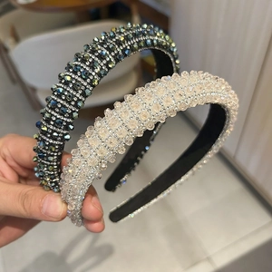 Close-up of luxury full crystal headbands in champagne and dark green with dense beadwork