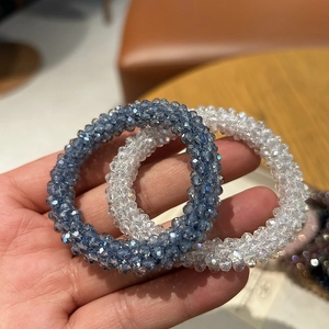 Elegant crystal beaded hair ties in blue and clear white on a female hand for daily use