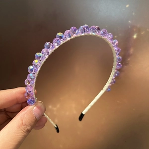 Gros plan détaillé du serre-tête en perles violettes irisées avec base tissée élégante