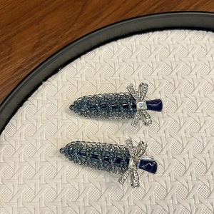 Detail of dark blue crystal-beaded carrot hair clips with silver bow accents