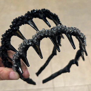 Detail view of handmade beaded punk headbands with black spikes and glossy resin pearls