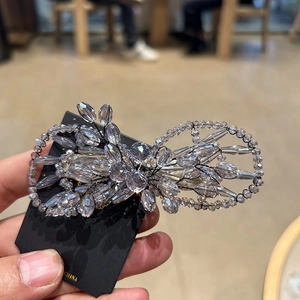 Détail d'une pince à cheveux avec perles en cristal violettes et travail de fil complexe
