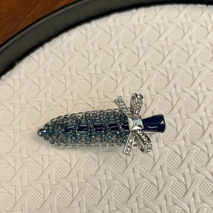 Detailed close-up of blue crystal beaded hair clip with silver rhinestone bow knot detail