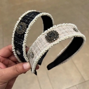 Close-up of retro tweed headbands with white pearl trim and baroque jewel details