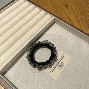 Elegant beaded hair tie featuring smoky grey faceted crystal cubes on a black elastic band