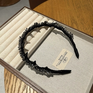Detailed macro view of black crystal beaded headband with rivets and luxury fabric wrapping