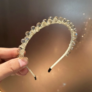 Détail d'un serre-tête de luxe fait main avec perles de cristal champagne et haute brillance