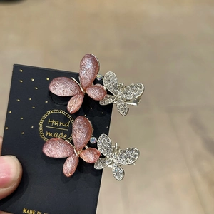 Vue détaillée des barrettes papillon avec paillettes roses et strass brillants