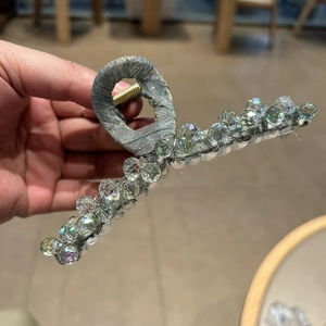 Detail of large hair claw clip with grey silk fabric and shimmering crystal bead accents