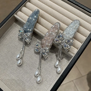 Vue détaillée de trois barrettes à cheveux ornées de strass brillants et de glands en perles