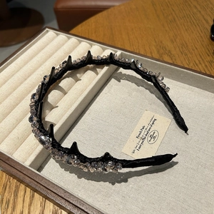 Detailed close-up of a black headband with champagne crystals and non-slip comb teeth