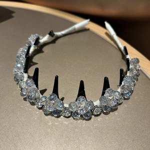 Macro shot of luxury hand-woven crystal flower headband on elegant champagne background