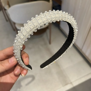 Close-up of luxury white crystal beaded headband with soft black velvet inner lining