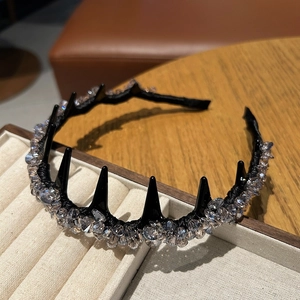 Detail of a black headband with shimmering grey crystals on a velvet display tray