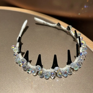 Nahaufnahme von funkelnden Kristallen und schwarzen Punk-Spikes am Luxus Stirnband