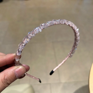 Détail macro du serre-tête en cristal rose fait main avec des pierres étincelantes sur métal