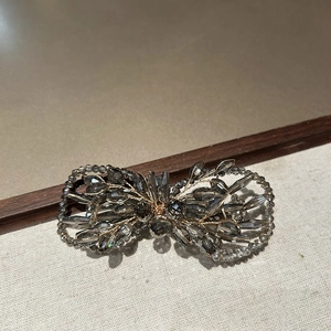 Détail macro de la barrette à cheveux nœud en cristal avec tissage de fil doré