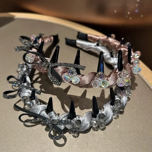 Detail of satin headbands with crystal beads and black rhinestone bows on a golden tray